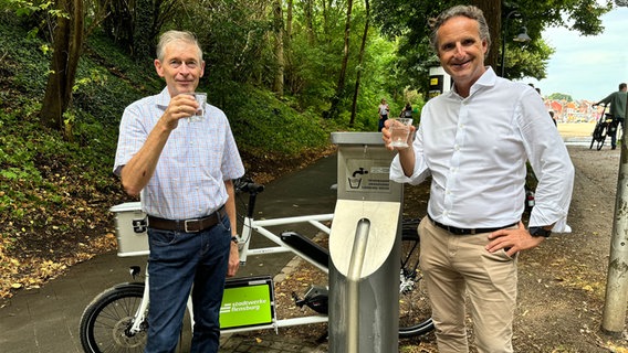 Zwei Männer halten ein Glas mit Trinkwasser in die Kamera. © Stadtwerke Flensburg 