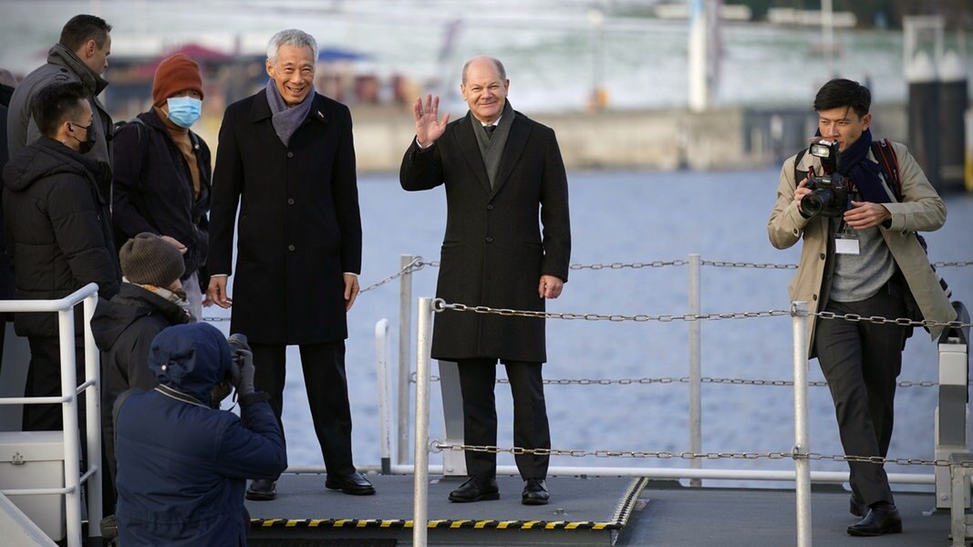 Bundeskanzler Olaf Scholz (2.v.r, SPD) und Lee Hsien Loong (3.v.r), Premierminister von Singapur, stehen an Bord des Küstenboots.