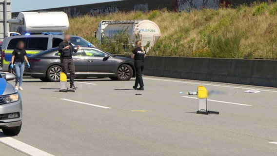 Einsatzkräfte der Polizei untersuchen einen Abschnitt auf der A7 nach einem schweren Unfall. © Daniel Friederichs 