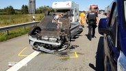 A7: Nach einem Unfall liegt ein Fahrzeug auf dem Dach. © NDR 