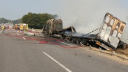 Einsatzkräfte der Feuerwehr löschen einen ausgebrannten Lkw auf der A21. © Daniel Friederichs 