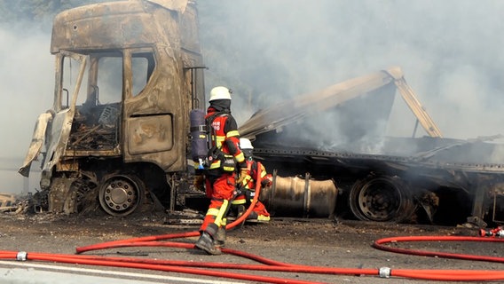 Einsatzkräfte der Feuerwehr löschen einen ausgebrannten Lkw. © Daniel Friederichs 