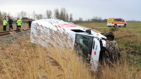 Ein DPD-Lieferwagen liegt neben Bahnschieben auf der Seite. Im Hintergrund ein Rettungsfahrzeug. © Florian Sprenger Foto: Florian Sprenger