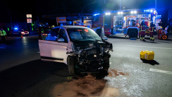 Ein stark beschädigtes Auto steht auf der Straße. Im Hintergrund arbeitet die Feuerwehr. © Digitalfotografie Nyfeler & Jappe Foto: Arne Jappe