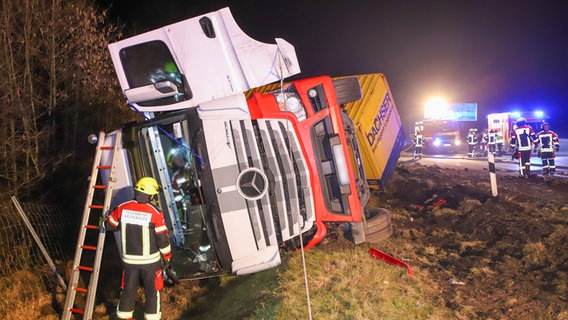 Auf dem Grünstreifen neben der A7 liegt ein umgekippter LKW. Die Feuerwehr ist im Einsatz. © Florian Sprenger Foto: Florian Sprenger