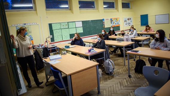 A teacher stands at the blackboard in front of the class.  © Gregor Fischer / dpa Photo: Gregor Fischer