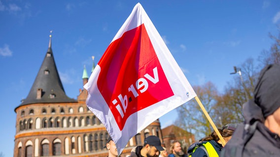 Eine verdi-Fahne vor dem Lübecker Holstentor. © IMAGO / Agentur 54 Grad 