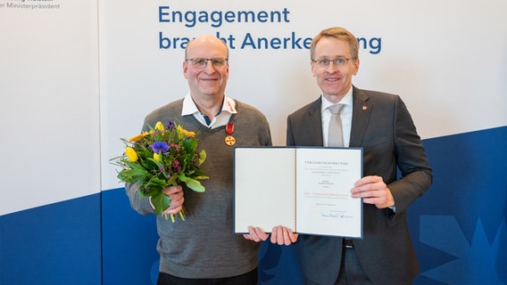 Gerrit Prenzin bekommt von Ministerpräsident Daniel Günther eine Verdienstmedaille überreicht. © Frank Peter Foto: Frank Peter