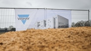 EIn Bauzaun mit dem Logo der neuen Halbleiter-Fabrik "Vishay" in Itzehoe. © Picture Alliance Foto: Christian Charisius