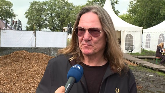 Ein Mann gibt ein Interview. Es ist der Mitgründer des Wacken Open Air, Thomas Jensen. © NDR Foto: NDR Screenshots