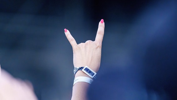 Eine Frau streckt die Hand mit einer Rock 'n' Roll Geste in die Luft © IMAGO / Eibner Foto: IMAGO / Eibner