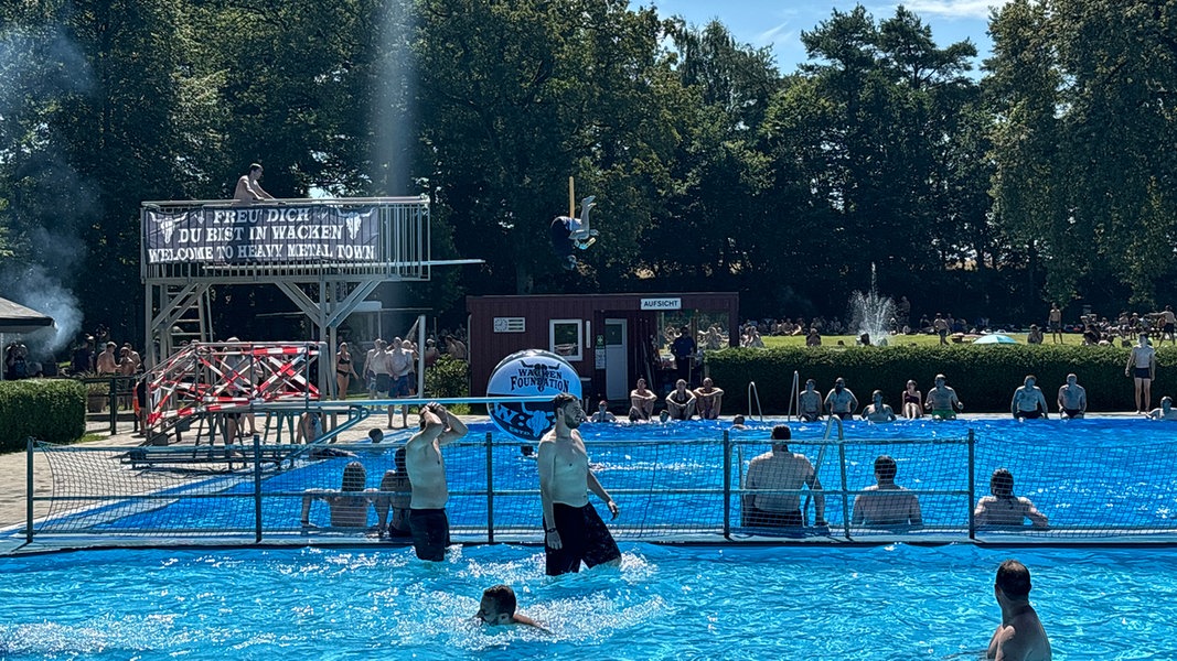 Zahlreiche Festivalbesucher des Wacken Open Air kühlen sich im Freibad Wacken ab.