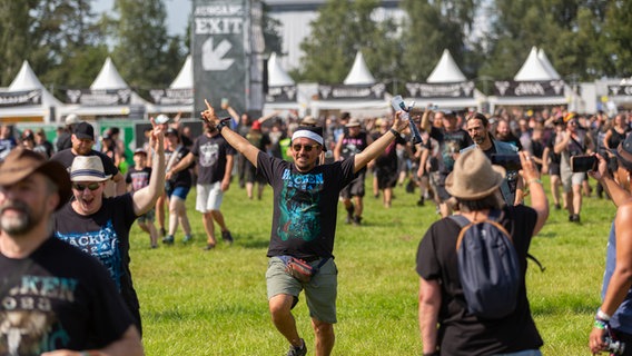 Menschen rennen jubelnd auf ein Festivalgelände. © NDR Foto: Dominik Dührsen