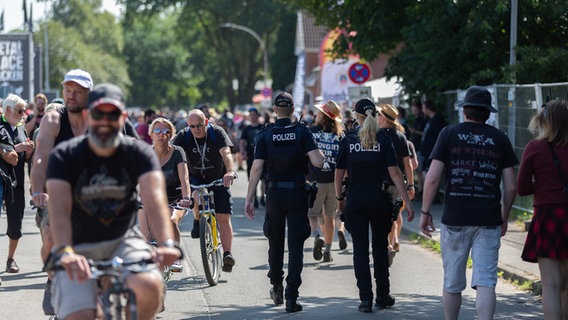 Ein Fahrradfahrer fährt über eine Straße voller Füßgänger. © NDR Foto: Dominik Dührsen