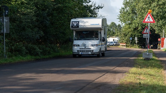 Ein Wohnmobil fährt über eine schlammige Straße. © NDR Foto: Dominik Dührsen