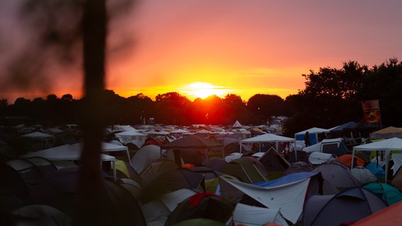 Ein Sonnenuntergang hinter einem Zeltplatz. © NDR Foto: Dominik Dührsen