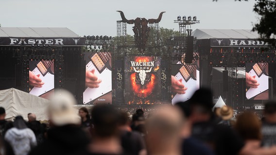 Zehntausende Menschen befinden sich auf einem Festivalgelände. Im Hintergrund eine große Bühne. © NDR Foto: Dominik Dührsen