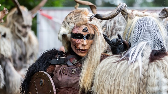 Eine Frau, die als Fabelwesen verkleidet ist, zeigt den Wacken-Gruß. © NDR Foto: Dominik Dührsen