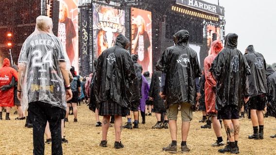 Festivalbesucher stehen beim Wacken Open Air bei heftigem Regen vor den Bühnen. © dpa-Bildfunk Foto: Axel Heimken