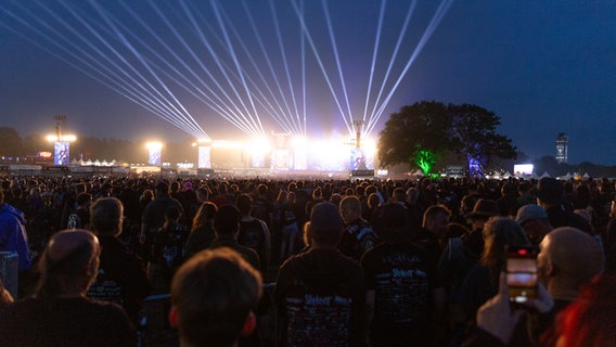 Zehntausende Menschen stehen vor einer hell erleuchteten Konzertbühne. © NDR Foto: Dominik Dührsen
