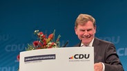 Johann Wadephul lächelt an einem Rednerpult auf einem Treffen der Landesvertreter der Nord-CDU in Neumünster. © NDR Foto: Stefan Böhnke