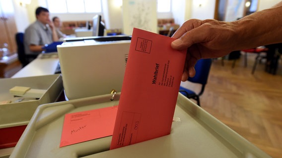 Eine Person wirft in einem Wahllokal ihren Briefumschlag in die Wahlurne. © picture alliance / dpa Foto: Carsten Rehder