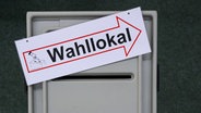 Auf einer Wahlurne liegt ein Schild mit der Aufschrift "Wahllokal". © picture alliance / dpa Foto: Patrick Pleul