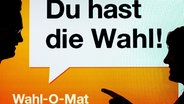 Zwei junge Leute stehen vor einen Bildschirm mit der Aufschrift "Du hast die Wahl! - Wahl-O-Mat". © picture alliance / Peter Kneffel/dpa Foto: Peter Kneffel