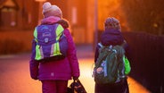 Zwei Schüler gehen am frühen Morgen auf dem Schulweg zu ihrer Grundschule. © picture alliance/dpa Foto: Julian Stratenschulte