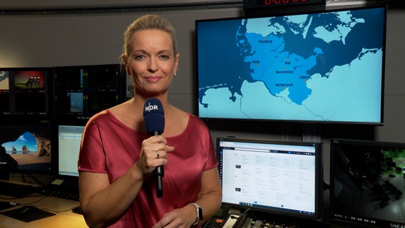 Wettermoderatorin Maike Jäger steht im Studio mit der Wettervorhersage. © NDR 