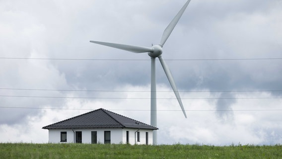 Blick auf ein Windrad neben einem Haus im Bürger Windpark Simmerath-Lammersdorf. © picture alliance/dpa Foto: Rolf Vennenbernd