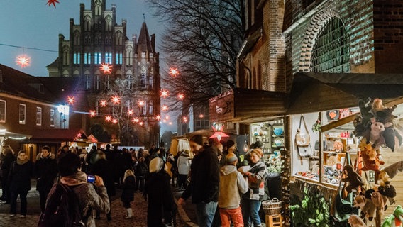 Blick auf den Lübecker Weihnachtsmarkt vor der Marienkirche, am Himmel hängen rot-leuchtende Sterne. © picture alliance / dpa | Markus Scholz Foto: Markus Scholz