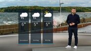 NDR Moderator Sebastian Wache steht im Studio mit der Wettervorhersage. © NDR 