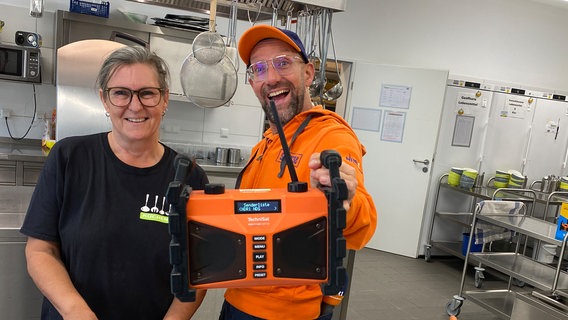 Schorse übergibt ein Dabbi DAB+ Radio an Kerstin Gramann und das Team der Küche in der "GO20KITA". © NDR Foto: Bernd Drechsler