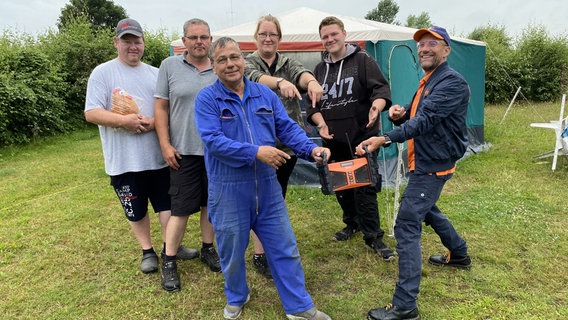 Schorse übergibt ein Dabbi DAB+ Radio an Thomas Glei und das Team vom Campingplatz Sandstedt. © NDR Foto: Bernd Drechsler