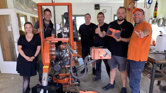 Schorse übergibt ein Dabbi DAB+ Radio an Robin Prüß und das Team des mobilen Sägewerks Wood Mizer. © NDR Foto: Bernd Drechsler