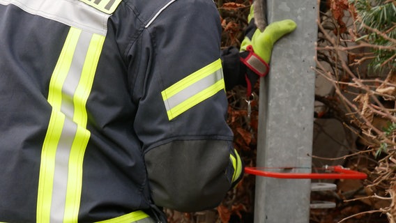 Ein Feuerwehrmann sägt ein Metallzaun auf © Feuerwehr Celle Foto: Feuerwehr Celle