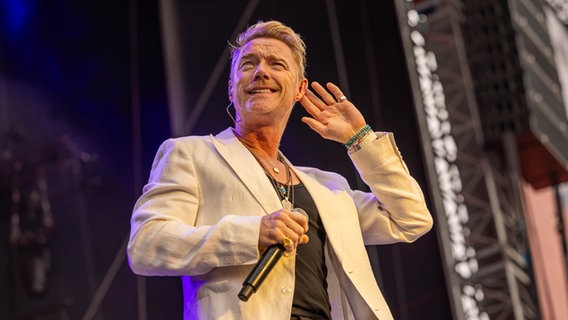 Ronan Keating lächelt verschmitzt und hält sich die Hand ans Ohr © NDR 2 Foto: Axel Herzig