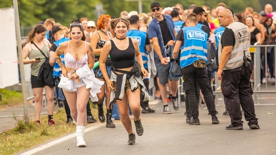 Ab in die erste Reihe: Zwei Besucherinnen laufen nach der Eingangskontrolle auf das Veranstaltungsgelände © NDR 2 Foto: Axel Herzig