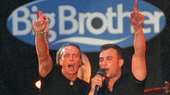 Jürgen (l) und Zlatko jubeln beim "Big Brother"-Finale am 9.6.2000 vor dem Logo der Sendung © Picture Alliance/dpa Foto: Ferdinand Ostrop