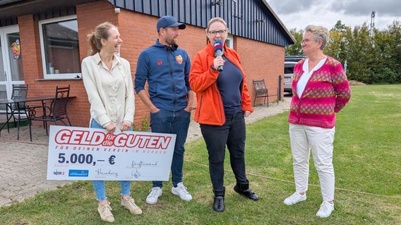 Gruppenfoto auf dem Platz der Nordic Tigers in Westerau mit Karolina Peik, Vereinsgründer Steven Torge, NDR 2 Reporterin Claudia Vierjahn und Bürgermeisterin Petra Jürß © NDR 2 