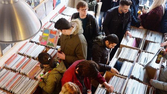 In einem Plattenladen sehen sich Menschen Schallplatten an. © picture alliance / John Stillwell/PA/dpa Foto: John Stillwell