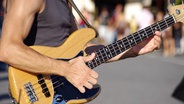 Ein Straßenmusiker in Paris spielt Bass. © IMAGO / Zoonar 