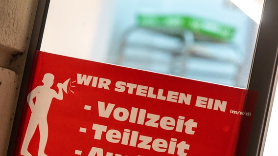 Ein rotes Schild mit der Aufschrift „Wir stellen ein - Vollzeit, Teilzeit, Aushilfen„ hängt am Eingang einer Bäckerei in der Innenstadt. © picture alliance/dpa | Peter Kneffel Foto: Peter Kneffel