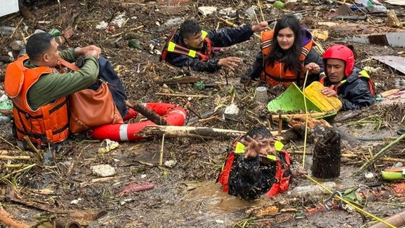 Menschen mit Rettungsschwimmwesten stehen in einer überfluteten Straße in Kathmandu, Nepal © picture alliance / Anadolu | Nepal Ministry of Home Affairs / Handout Foto: Anadolu