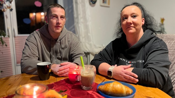 Ein Ehepaar sitzt am Frühstückstisch und schaut in Richtung Kamera © Christoph Deuschle Foto: Christoph Deuschle