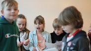 Konzertszene: Kinder mit Programmheften singen © NDR Foto: Marcus Krüger