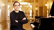 Pianist Pierre-Laurent Aimard mit verschränketen Armen vor dem Flügel © Julia Wesely Foto: Julia Wesely