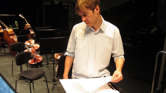 Stefan Geiger mit Partitur auf der Kampnagel-Bühne. © NDR Sinfonieorchester 