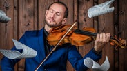 Portrait Antoine Tamestit spielt auf der Bratsche während es Notenblätter regnet. © lenaka.net Foto: LenaKa